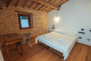 a bedroom with a bed and a desk in a room at Tenuta del Picchio in Colombara