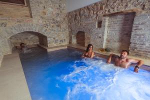 a man and a woman sitting in a hot tub at Tenuta del Picchio in Colombara