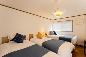 a room with three beds and a window at DAI HOSTEL Ayase in Fukaya +35 photos