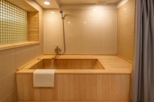 a bath tub in a bathroom with a shower at The Seaes Hotel & Resort in Seogwipo