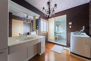 a bathroom with a sink and a washing machine at DAI HOSTEL Ayase in Fukaya
