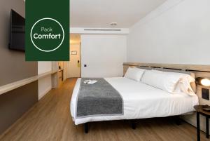 a bedroom with a bed and a green sign that reads pack comfort at Sercotel Delfos Andorra in Andorra la Vella