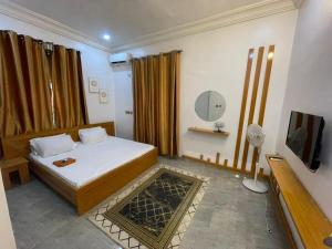 a bedroom with a bed and a tv in it at Pristine Apartment in Gwagalada
