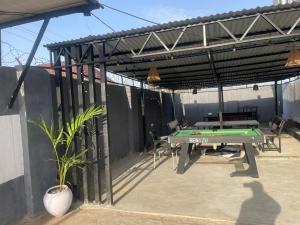 a patio with a ping pong table on the side of a building at Pristine Apartment in Gwagalada
