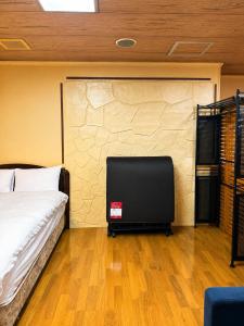 a bedroom with a bed and a tv in a room at Local LifeYOMITAN in Yomitan