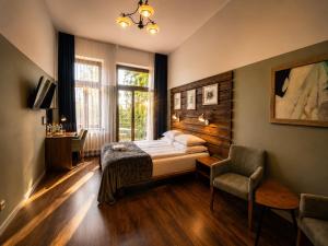 a bedroom with a bed and a chair and a window at Pensjonat Pod Jemiołą in Ciechocinek +159 photos