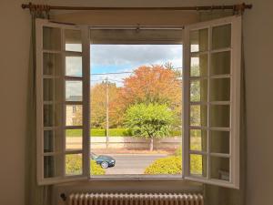 an open window with a view of a car at Chambre spacieuse in Pineuilh
