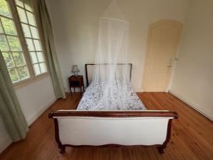 a bedroom with a bed with a veil on it at Chambre spacieuse in Pineuilh
