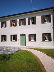 a white building with a green door and a driveway at L'Albero del Tempo in Falze