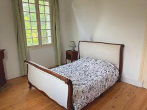 a bedroom with a bed in a room with two windows at Chambre spacieuse in Pineuilh