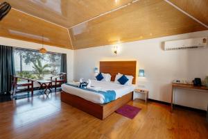 a bedroom with a large bed and a dining room at Sea Shells Beach Resort Agatti in Agatti