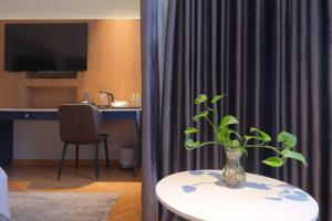 a room with a table with a vase on it at Ngan Ha Hotel - Ben Thanh Central in Ho Chi Minh City