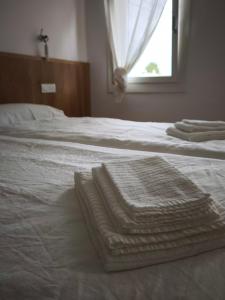 a white bed with towels on it with a window at L'Albero del Tempo in Falze +4 photos