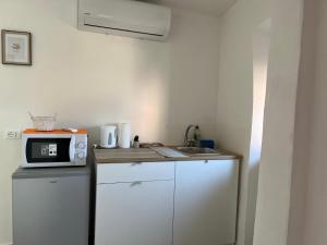 a small kitchen with a microwave and a sink at La Bella e La Bestia in Lierna
