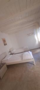 a white bed in a room with a white ceiling at La Bella e La Bestia in Lierna +3 photos