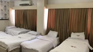 a group of three beds in a room at Chwar chra hotel in Erbil