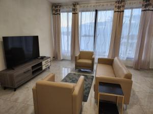 a living room with couches and a flat screen tv at Entre Ciel et Lagon in Mtsamboro