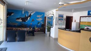 a restaurant with a fish mural on the wall at Pousada H&D in Angra dos Reis