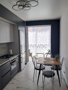 a kitchen with a table and chairs in a kitchen at ЖК Dream Town, Lutsk in Lutsk