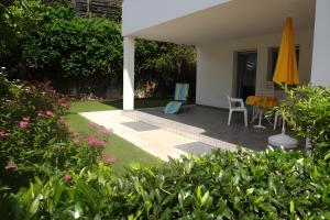 a patio with a table and chairs and an umbrella at Renates Ferienwohnungen in Meltina