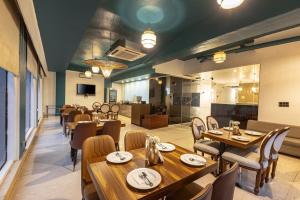 a dining room with wooden tables and chairs at Skon Boutique by Orion Hotels in Delhi +30 photos