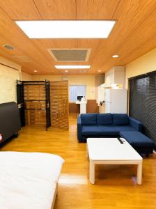 a living room with a blue couch and a table at Local LifeYOMITAN in Yomitan