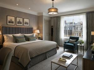 a bedroom with a bed and a chair and a window at Metropole Hotel in London