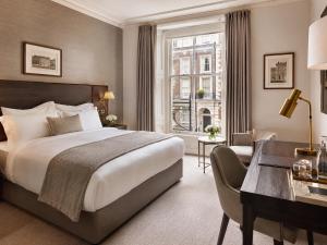 a hotel room with a bed and a desk at Metropole Hotel in London