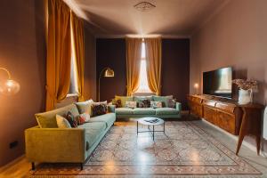 a living room with two couches and a tv at VILLA SUMAC 6, Emma Villas in Sortino