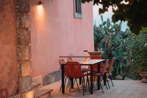 a table and chairs on a patio with cactus at VILLA SUMAC 6, Emma Villas in Sortino