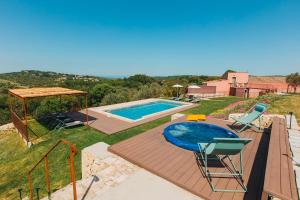 a villa with a swimming pool and two chairs at VILLA SUMAC 6, Emma Villas in Sortino