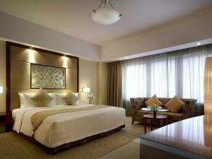 a hotel room with a large bed and a couch at the glory stay in Amritsar