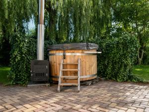 a wooden chair sitting next to a wood stove at Villa Vera - Comfort, Space, Sauna & Hot Tub in Private Garden in Zeewolde +51 photos