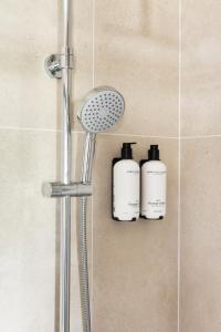 a shower with two shampoo bottles on the wall at B&B De Lijsterhof in Domburg +27 photos