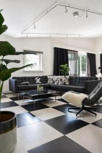 a living room with a black and white checkered floor at Villa Vera - Comfort, Space, Sauna & Hot Tub in Private Garden in Zeewolde