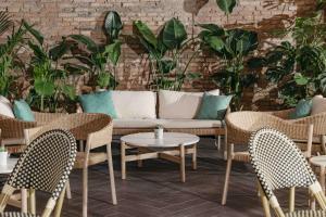 a patio with chairs and a couch and tables at La França Hotel Boutique in Barcelona
