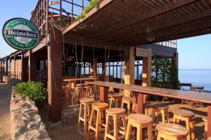 a bar with wooden stools in front of a restaurant at Blue Beach Club Apartment in Dahab