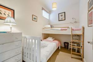 a bedroom with two bunk beds and a dresser at Giddy Cottage in Eastdean