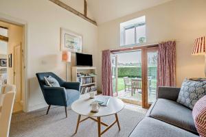 a living room with a couch and a table at Giddy Cottage in Eastdean