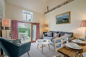 a living room with a couch and a table at Giddy Cottage in Eastdean