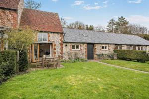 an exterior view of a brick house with a yard at Giddy Cottage in Eastdean