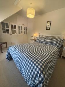 a bedroom with a blue and white checkered bed at Cotford Cottage in Sidmouth