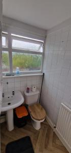 a bathroom with a toilet and a sink and a window at Cozy Private Room Near Everything in Kent