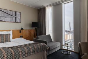 a hotel room with a bed and a chair and a window at Clarion Hotel Malmö Live in Malmö