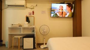 ein Zimmer mit einem Bett und einem Fernseher an der Wand in der Unterkunft Dal Hotel in Seoul
