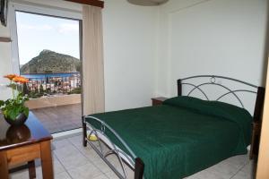 トロにあるIliana Apartmentsのベッドルーム(緑のベッド1台、バルコニー付)