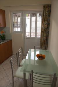 トロにあるIliana Apartmentsのキッチン(テーブル、椅子、オレンジボウル付)