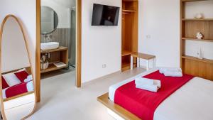 ein Schlafzimmer mit einem Bett mit einer roten Decke und einem Spiegel in der Unterkunft Corallo Home Resort in Le Castella + 41 Fotos