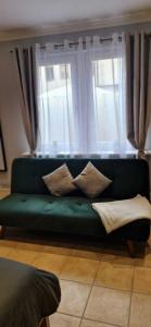 a green couch sitting in front of a window at Ela´s Alstadtliebe in Wertheim +17 photos