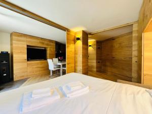 a bedroom with a bed with two towels on it at GuestHost - Mulino del Bianco - Comfy Studio-Flat in La Thuile
